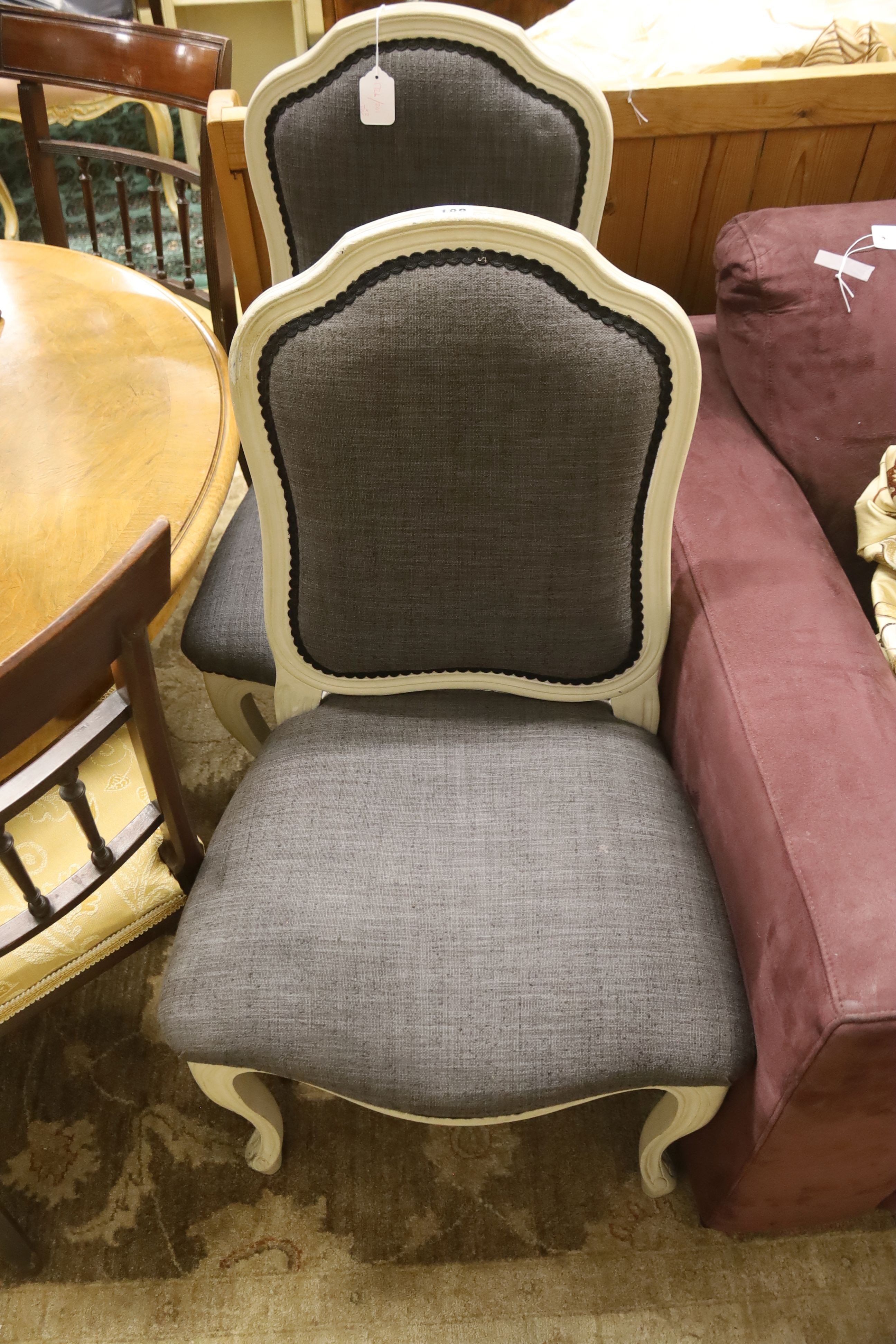 A pair of grey upholstered dining chairs